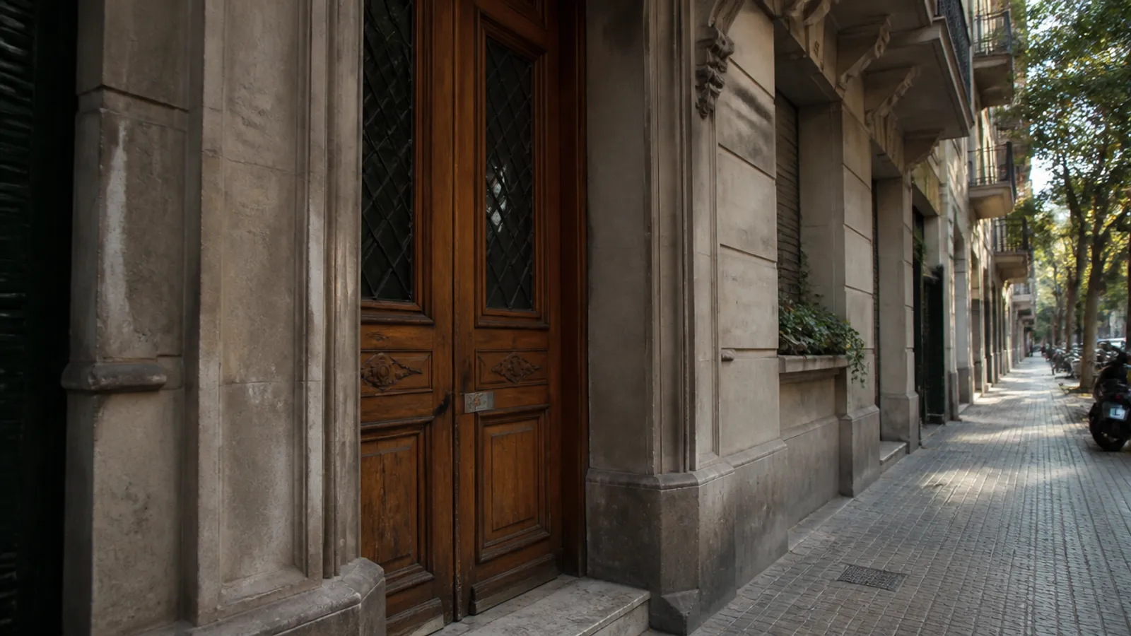 Portal de un piso del Eixample de Barcelona con cerradura en la puerta de madera, servicio de cerrajero a domicilio